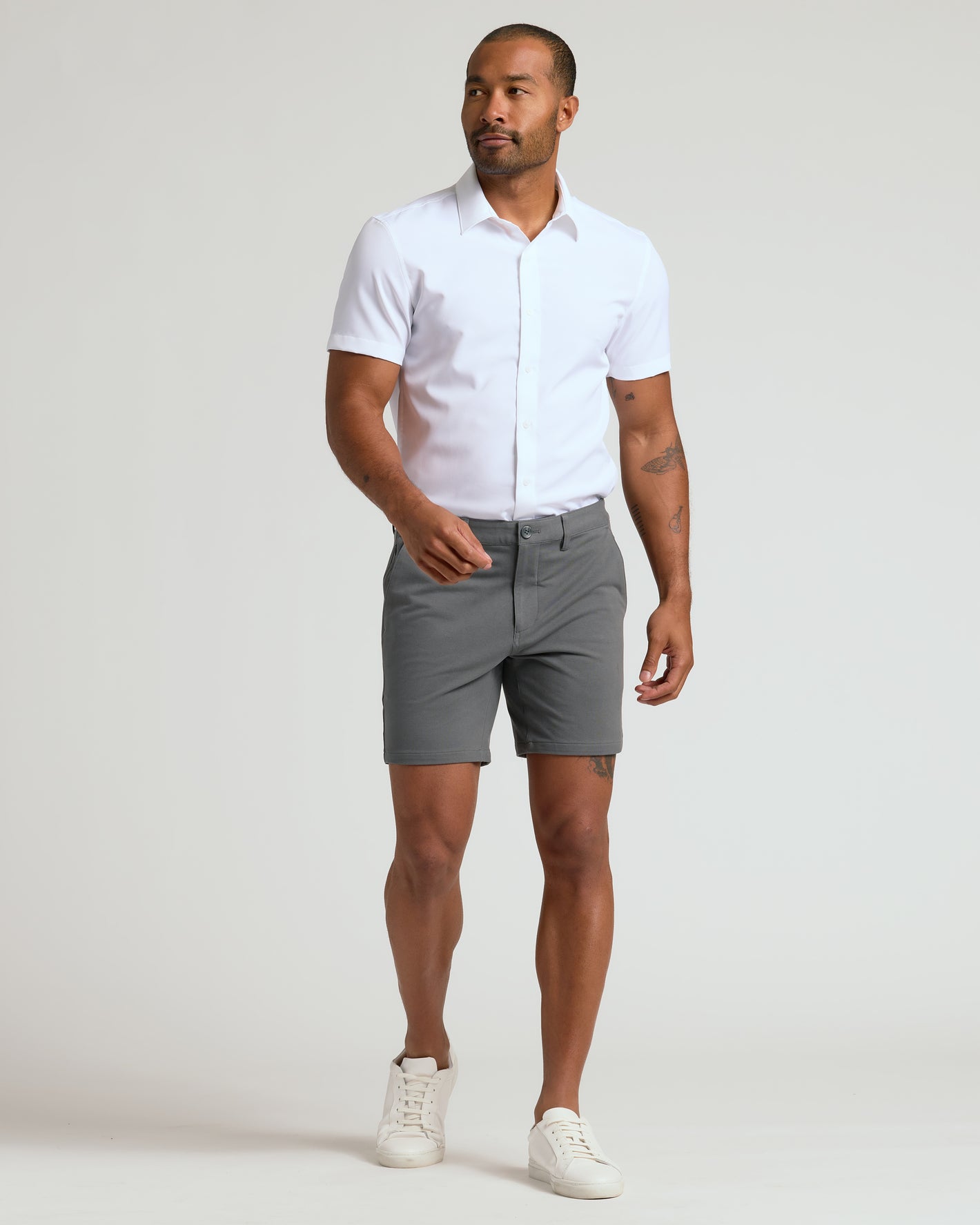 Man in 7 Carbon Chino Shorts 2.0, white shirt, sneakers.