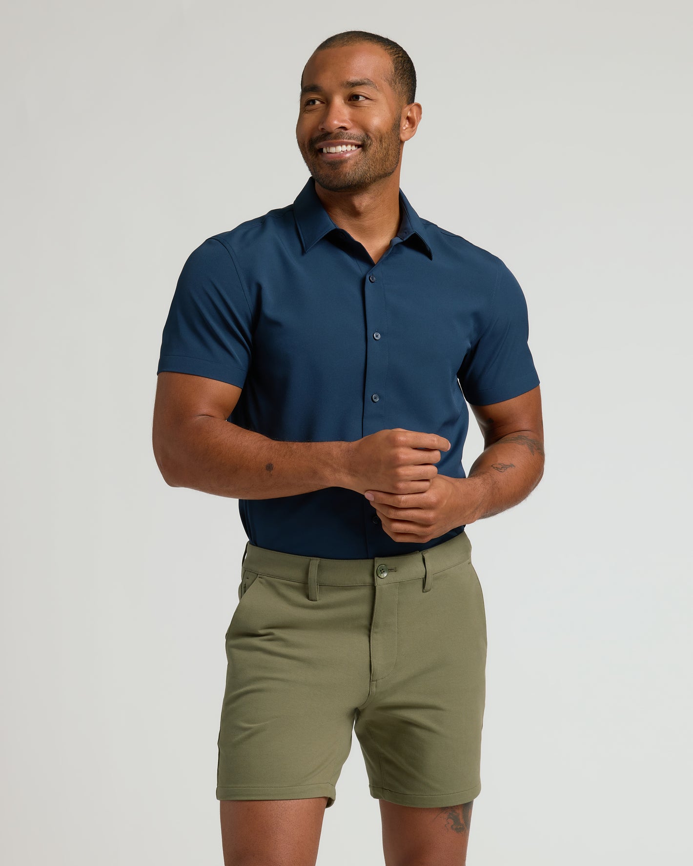 Man in 7 Military Green Classic Chino Shorts, smiling casually.