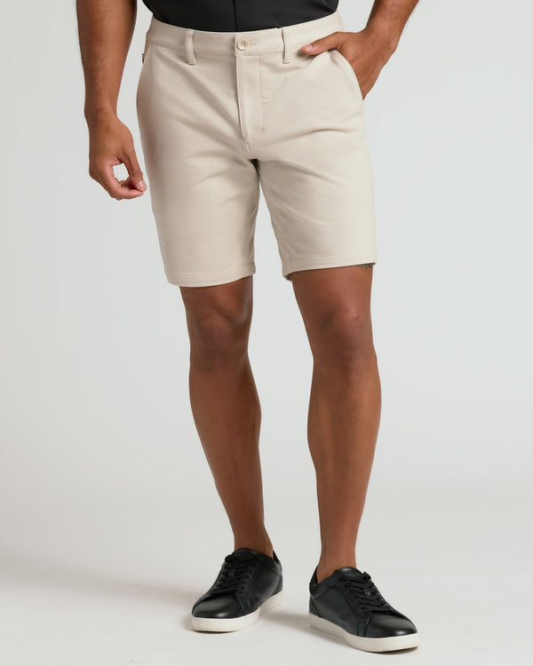 7 Sandstone Chino Shorts 2.0 with side pockets and black sneakers.