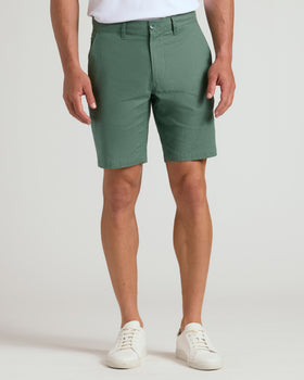 Man wearing 9 Moss Linen Shorts with white sneakers.