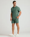 Model wearing 7 Moss Linen Shorts with matching shirt and white sneakers.