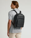 Man wearing Premium Leather Backpack with padded straps and sleek design.