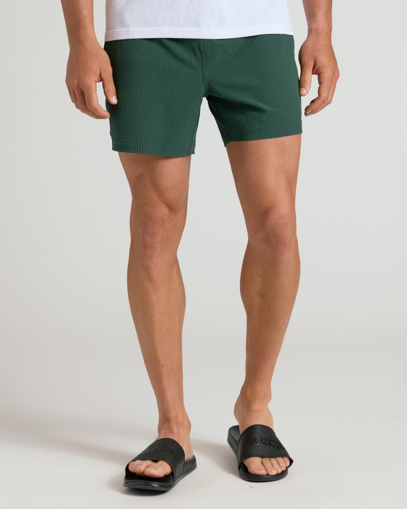 Black Comfort Slides with cushioned sole and wide strap, worn with textured shorts.