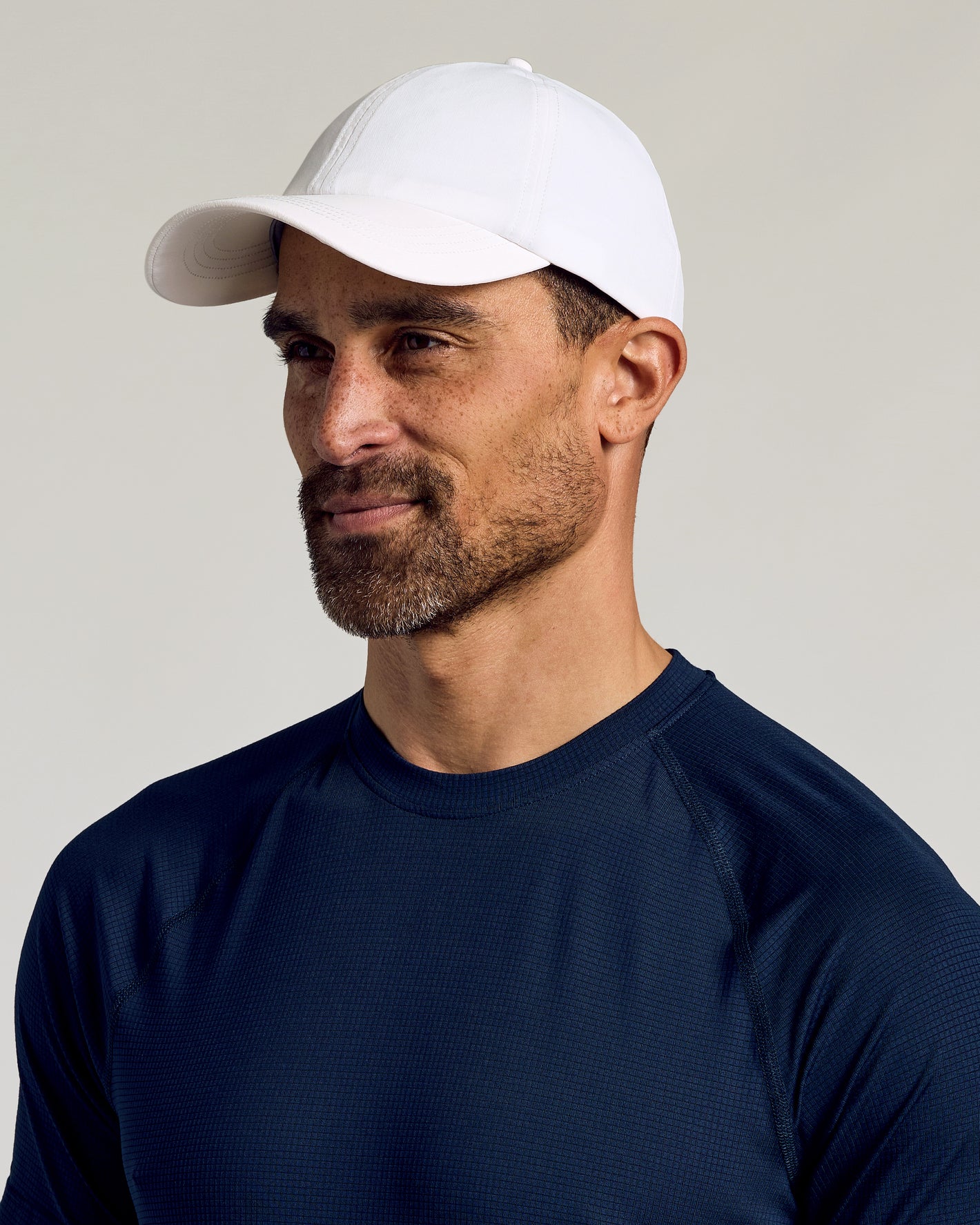 White Active Running Cap on male model, showcasing breathable design and secure fit.
