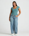 Woman in Womens Stormcloud Ribbed U-Neck Tee and jeans, smiling.