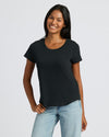 Woman wearing a black t-shirt and light blue jeans on a white background