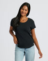 Woman wearing a black t-shirt and light blue jeans on a white background