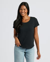 Woman wearing a black t-shirt and light blue jeans on a white background