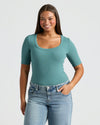 Woman wearing Womens Ribbed 3/4 Sleeve Scoop Neck Tee tucked into jeans.