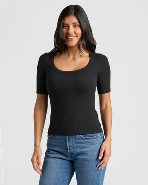 Woman in Womens Black Ribbed 3/4 Sleeve Scoop Neck Tee, smiling. MODEL_INFO: Sophia is 5'8", wearing a size XS