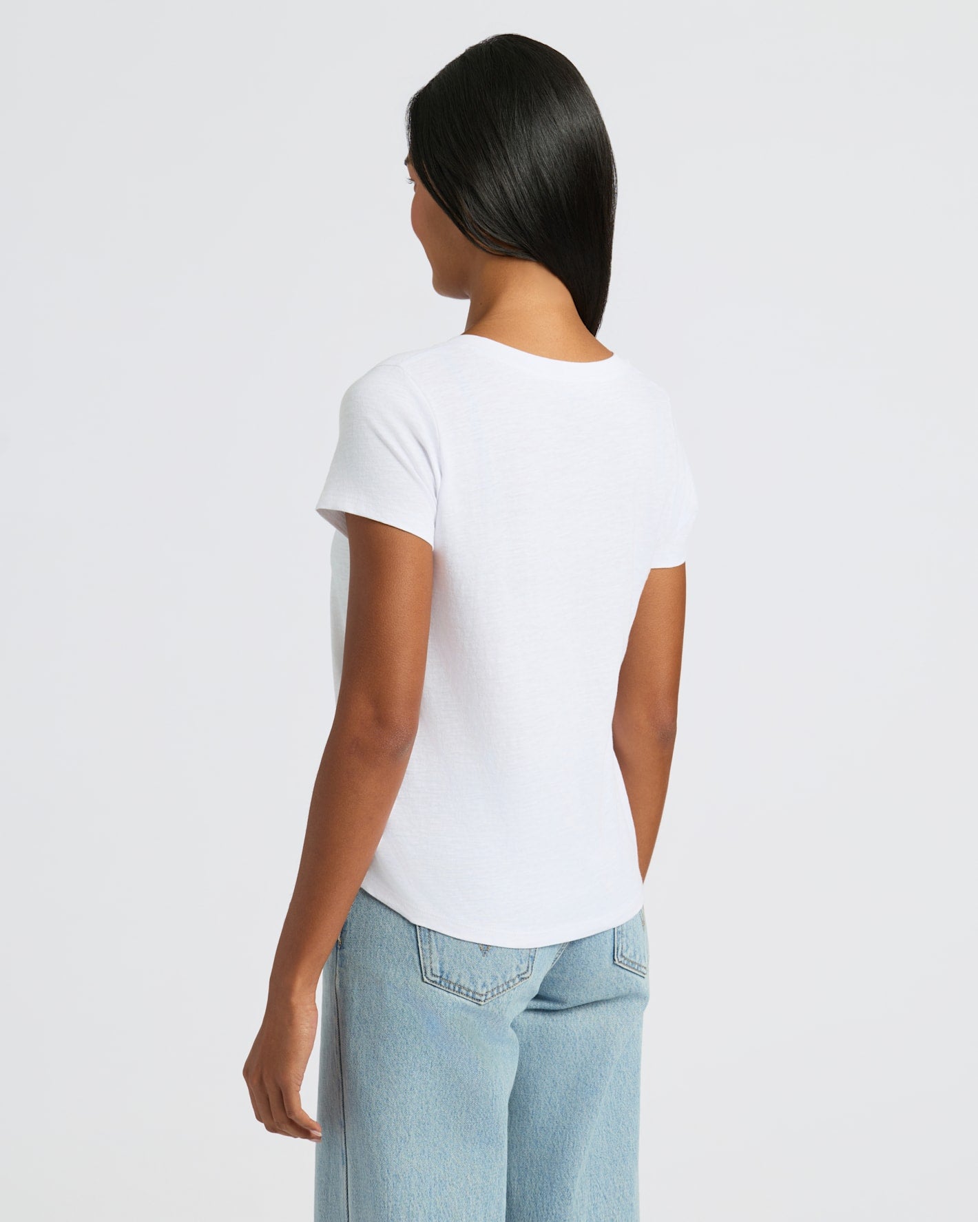 Woman wearing Womens White Relaxed Slub V-Neck Tee 4-Pack with jeans.