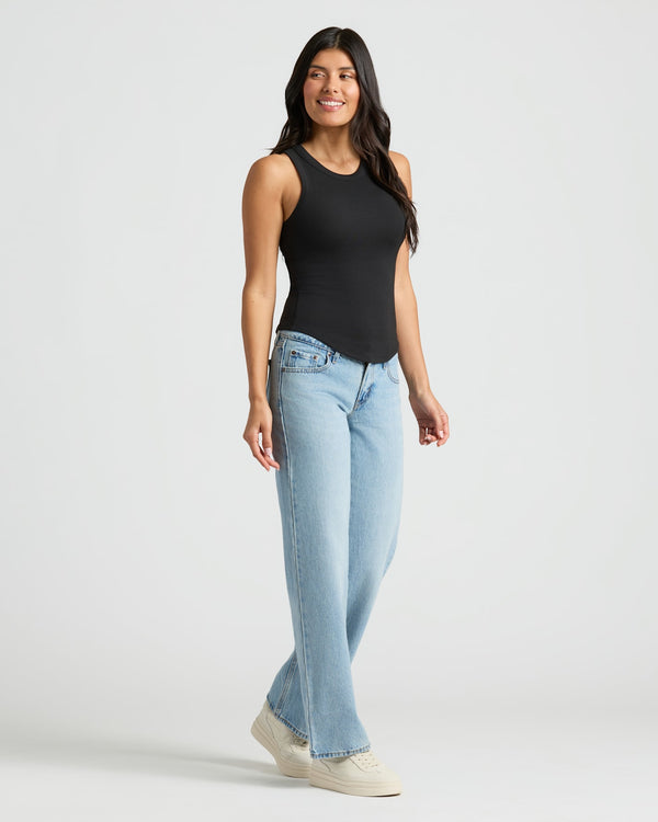 Woman in Womens Black Ribbed High Neck Tank 3-Pack, jeans, sneakers.