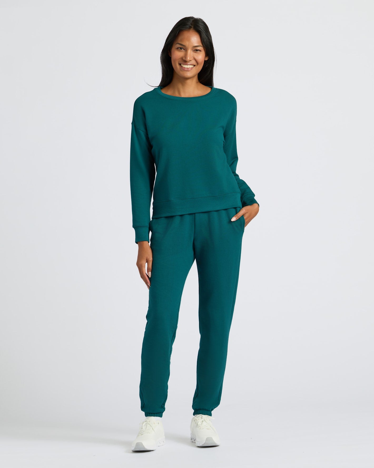 Woman in Womens Deep Emerald Slouch Pullover Crew with joggers and sneakers.