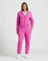 Woman in Womens Electric Fuchsia Crop Zip Hoodie, smiling with hand in pocket.