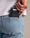 Black Classic Wallet in back pocket of light-wash jeans.