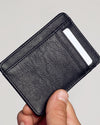Black Classic Wallet in hand, showcasing pebbled vegan leather and card slot.