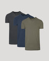 Three plain t-shirts in black, blue, and green on a light gray background