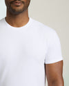Man wearing a plain white t-shirt against a neutral background