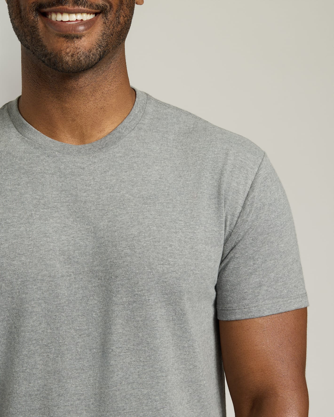 Man wearing a gray t-shirt against a plain background