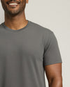 Man wearing a gray t-shirt against a plain background