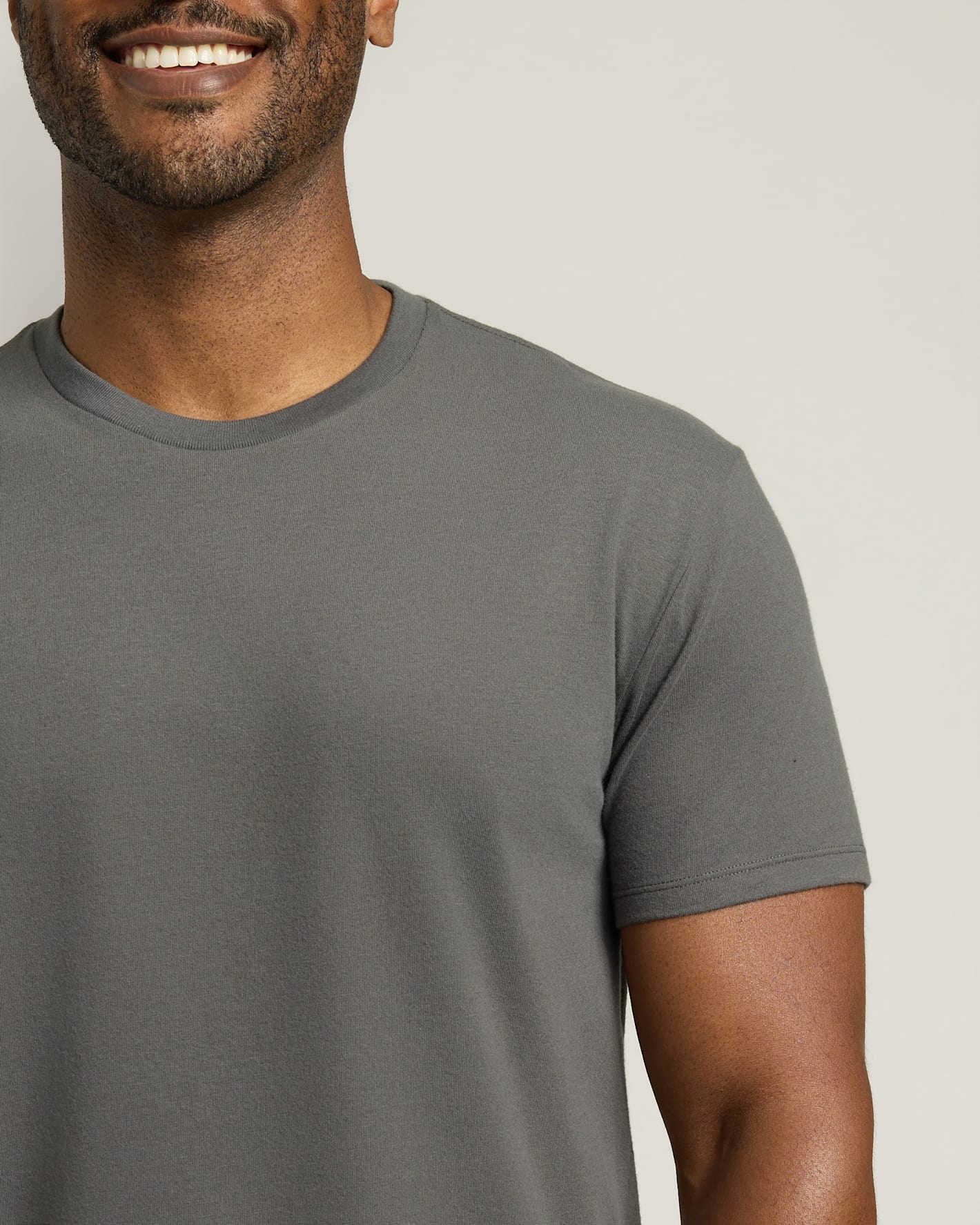Man wearing a gray t-shirt against a plain background
