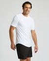 Man wearing a white t-shirt and black shorts on a light gray background