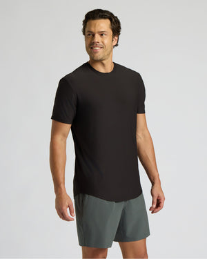 Man wearing a black t-shirt and gray shorts on a light gray background