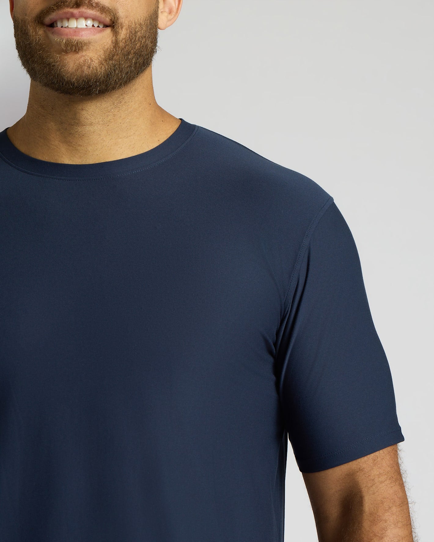 Man wearing a navy blue t-shirt against a plain background