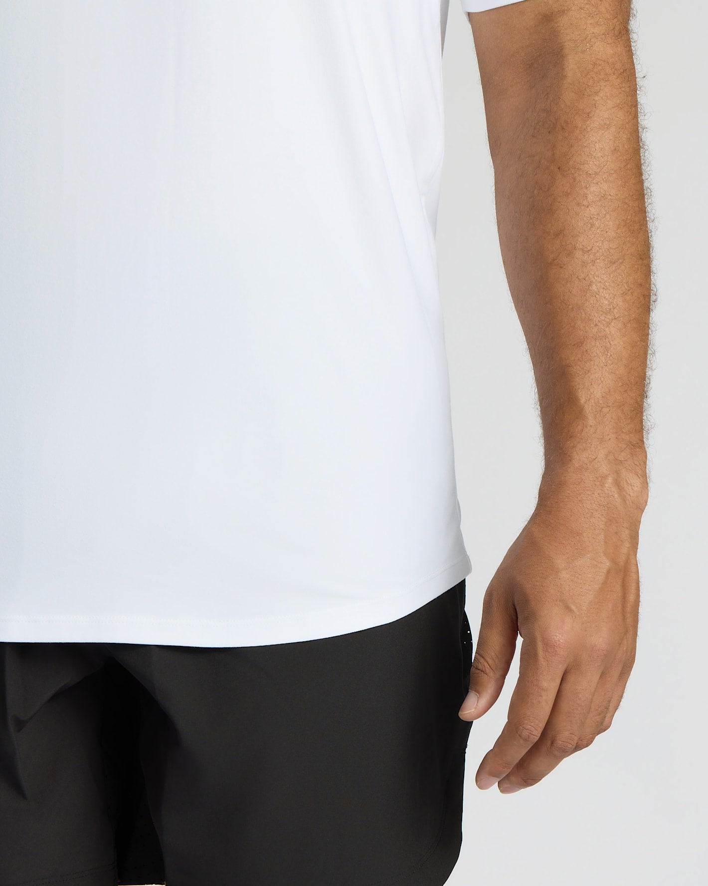 Person wearing a white shirt and black pants on a plain background