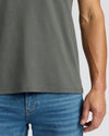 Person wearing a gray t-shirt and blue jeans on a plain background