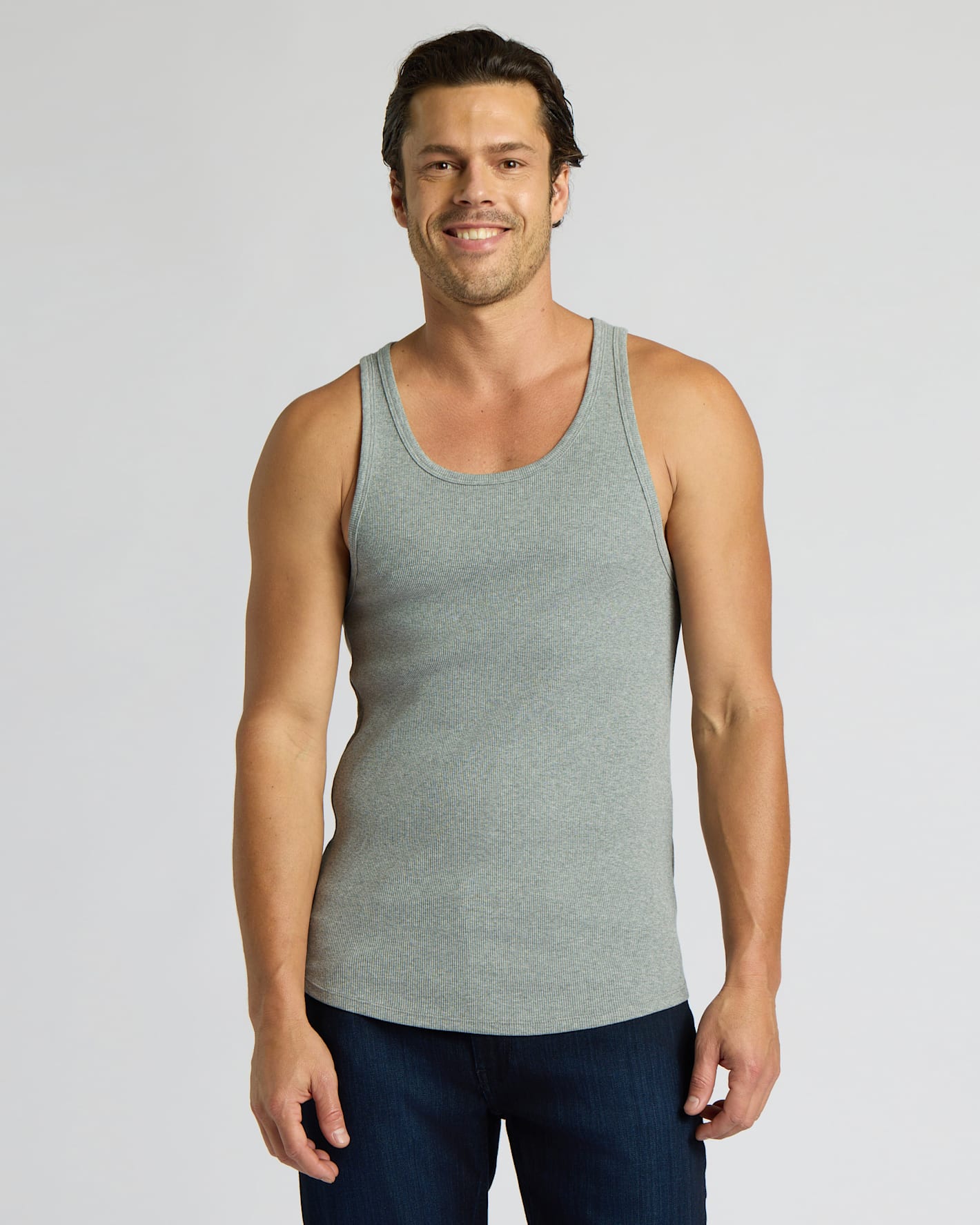 Man wearing a gray tank top against a plain background