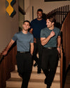 Men wearing Blue Tones Classic Tall Premium Pima Crew 4-Pack tees descend stairs.