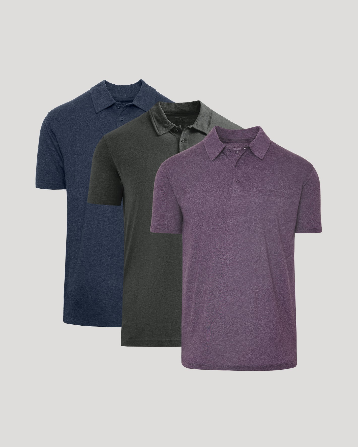 Three polo shirts in blue, gray, and purple on a light gray background