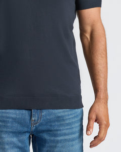 True ClassicNavy Dressy Polo with short sleeves, tucked into blue jeans.
