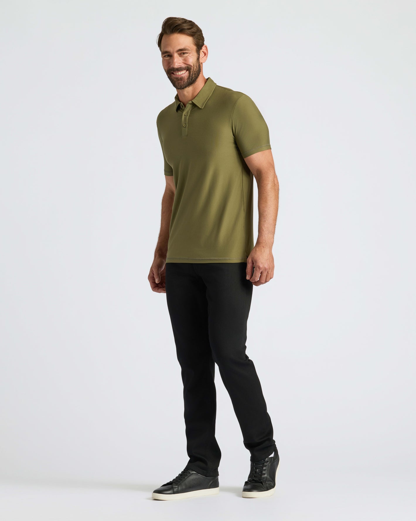 Man modeling Military Green Active Polo 2.0 with black slim-fit pants.