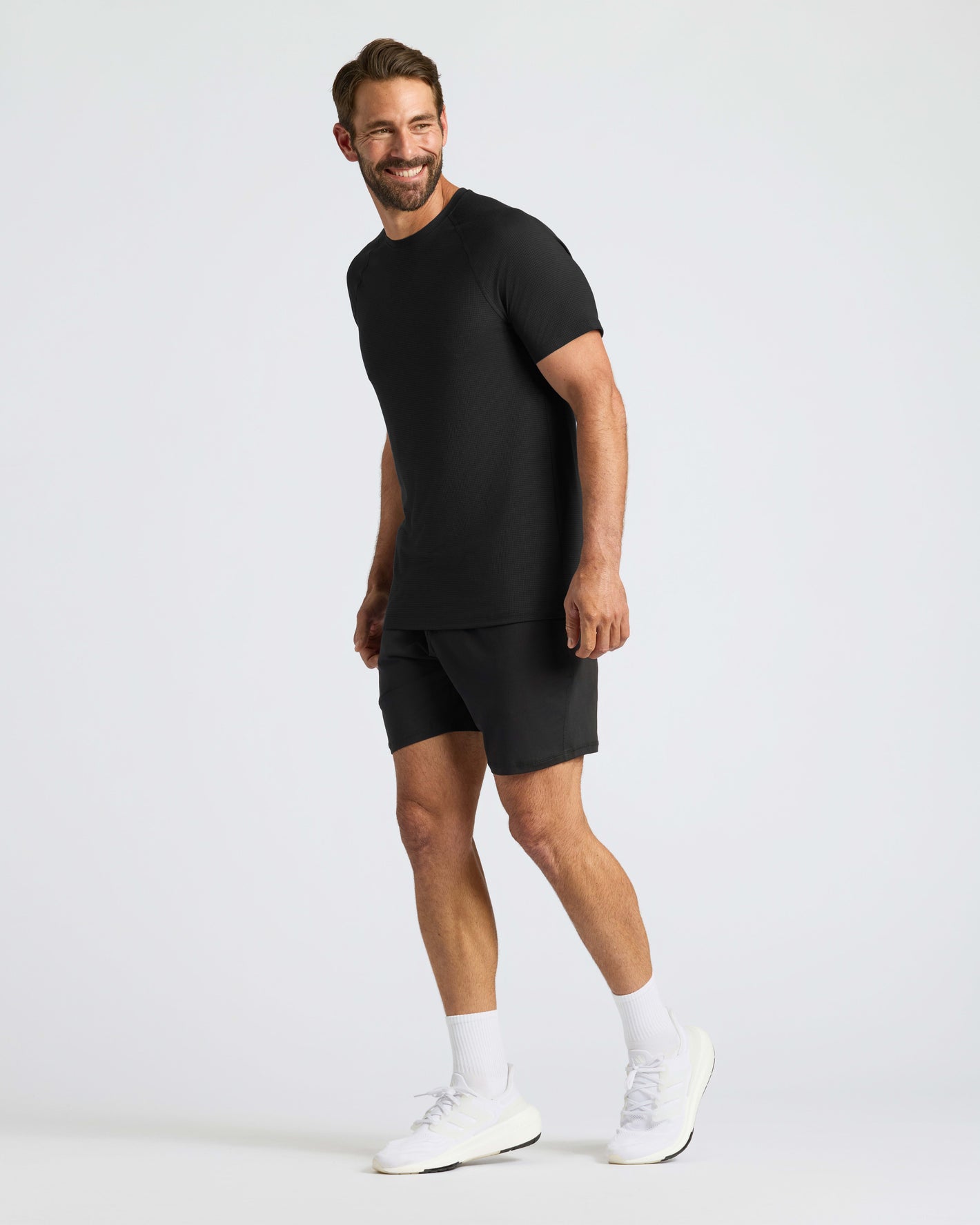 Man in Black Active Mesh Crew 6-Pack, smiling, relaxed pose.