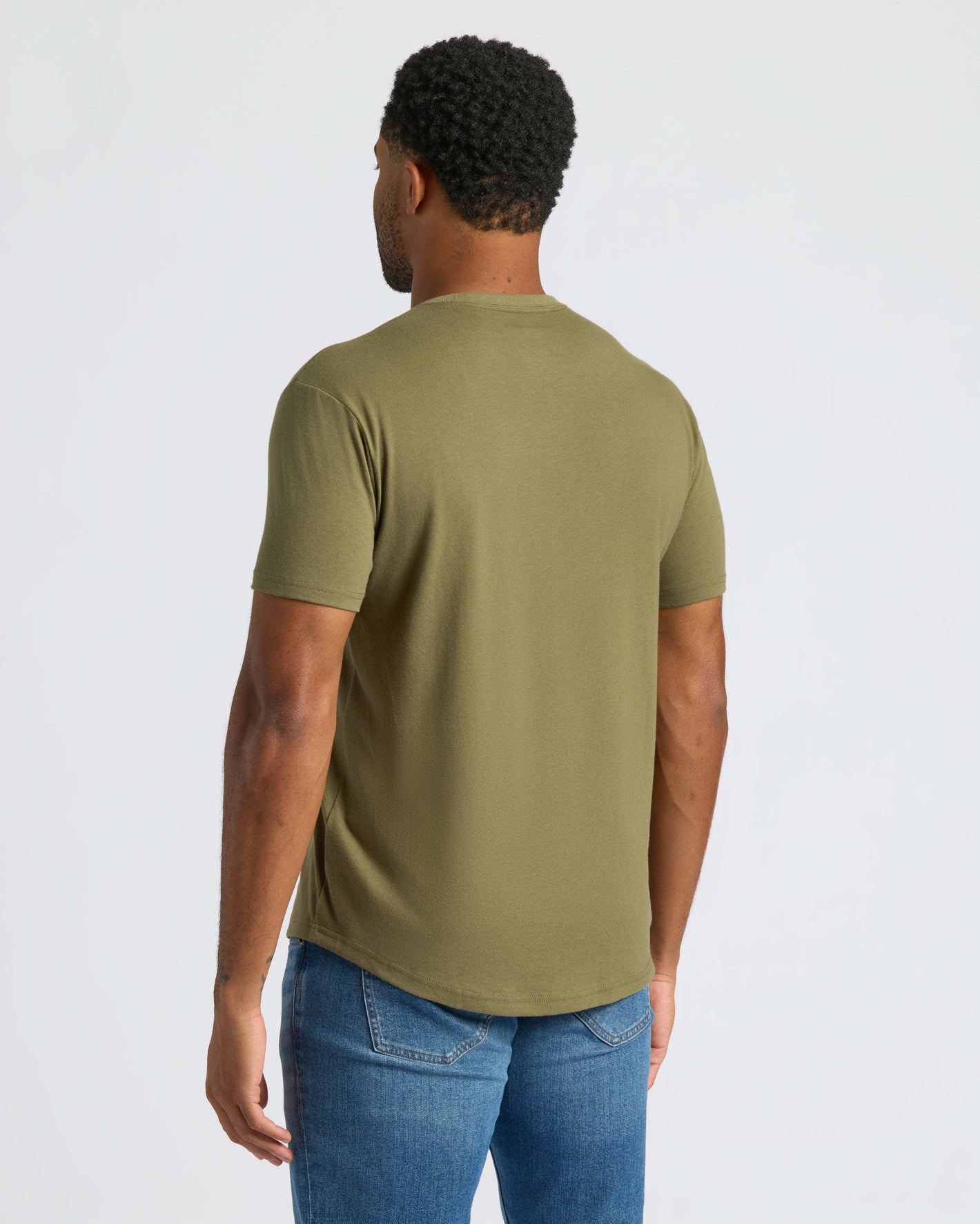 Man wearing Military Green Curved Hem Classic Crew Neck and blue jeans.