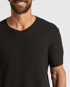 True ClassicMan wearing All Black Classic V-Neck T-Shirt, smiling slightly.