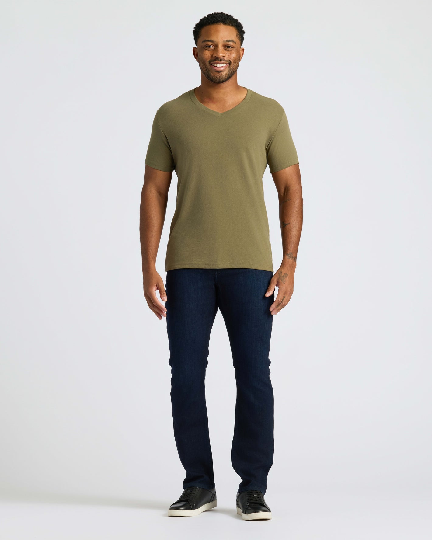 Man wearing Classic V-Neck, slim-fit jeans, and sneakers.