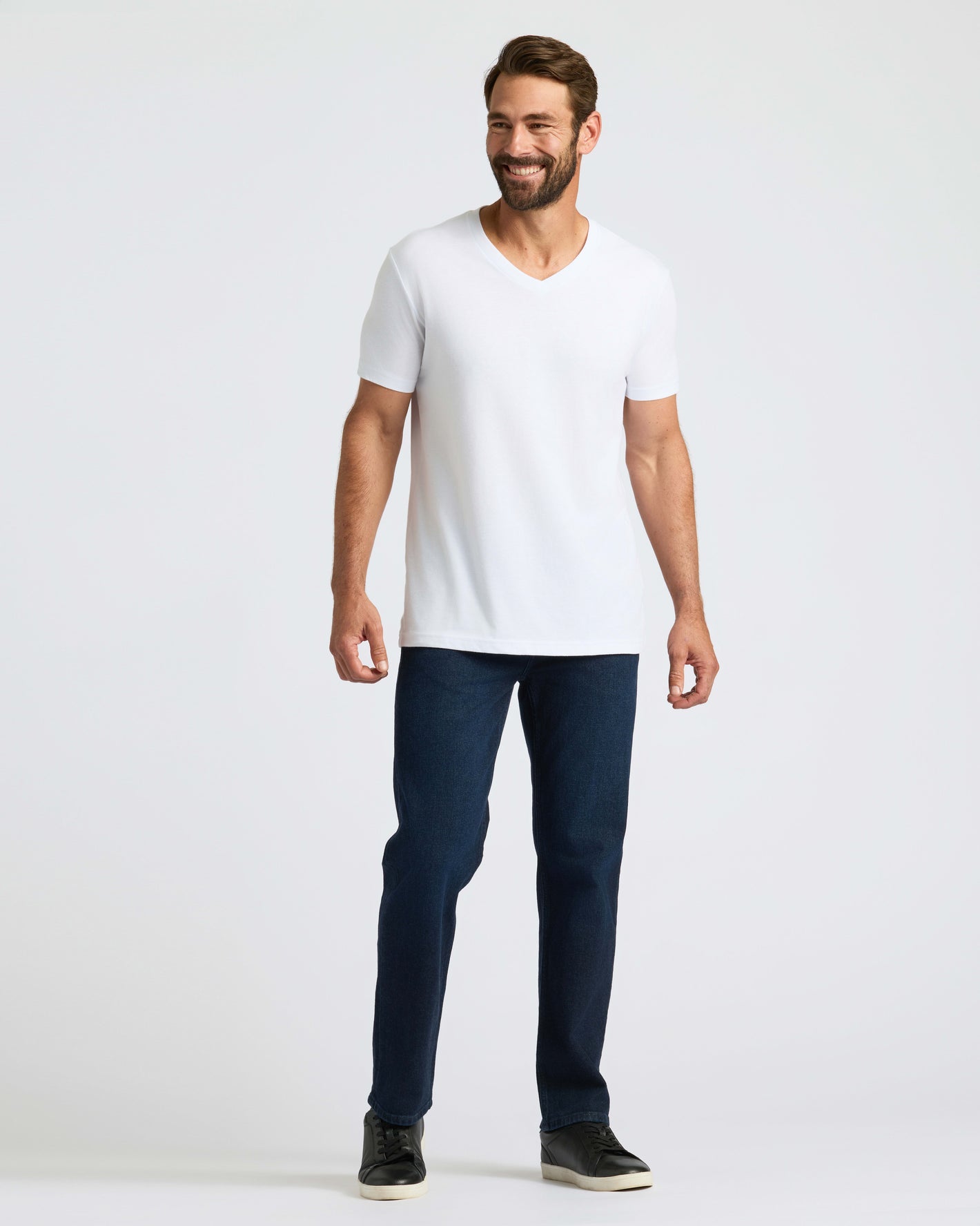 Man wearing All White Classic V-Neck 10-Pack, dark jeans, black sneakers.