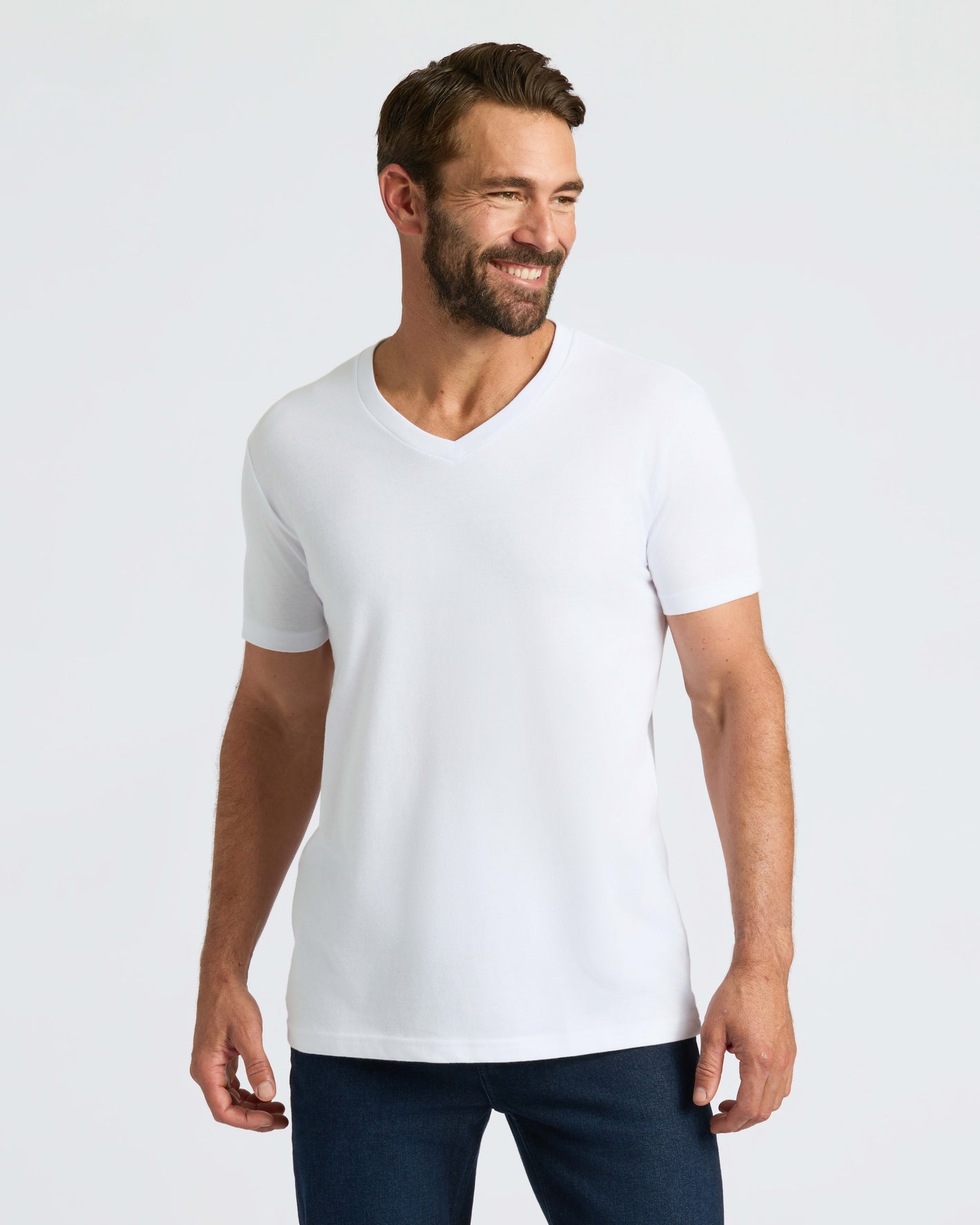 Man in fitted All White Classic V-Neck, smiling confidently.