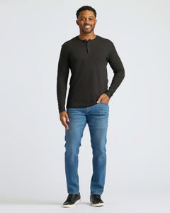True ClassicMan wearing All Black Classic Henley, smiling, left hand in pocket.