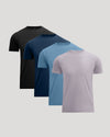 Four short-sleeve crew-neck t-shirts in black, navy, light blue, and dusty lavender, arranged in a staggered diagonal stack on a light gray background.