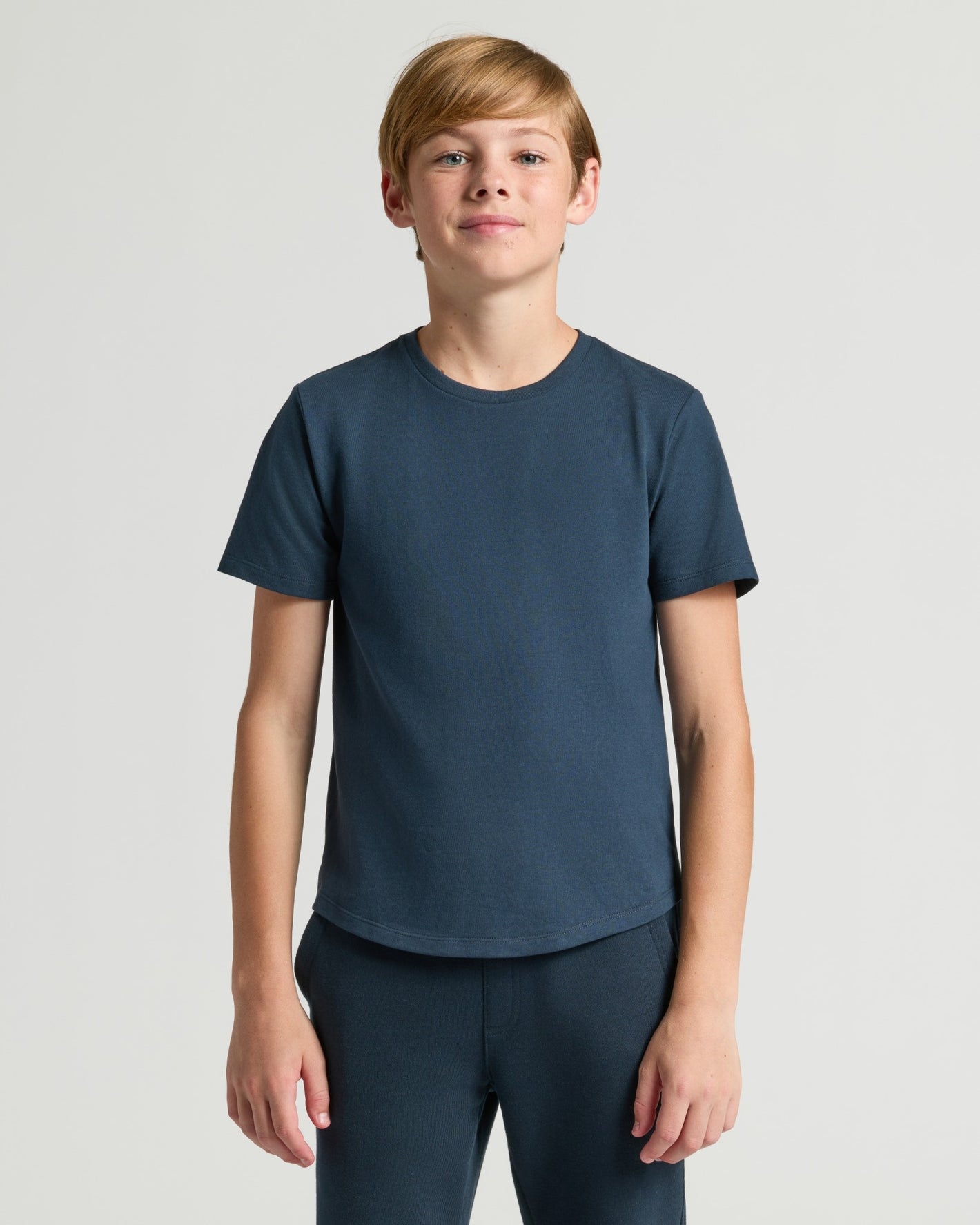 Boy wearing Boys' Classic Curved Hem Crew Neck T-shirt and pants.