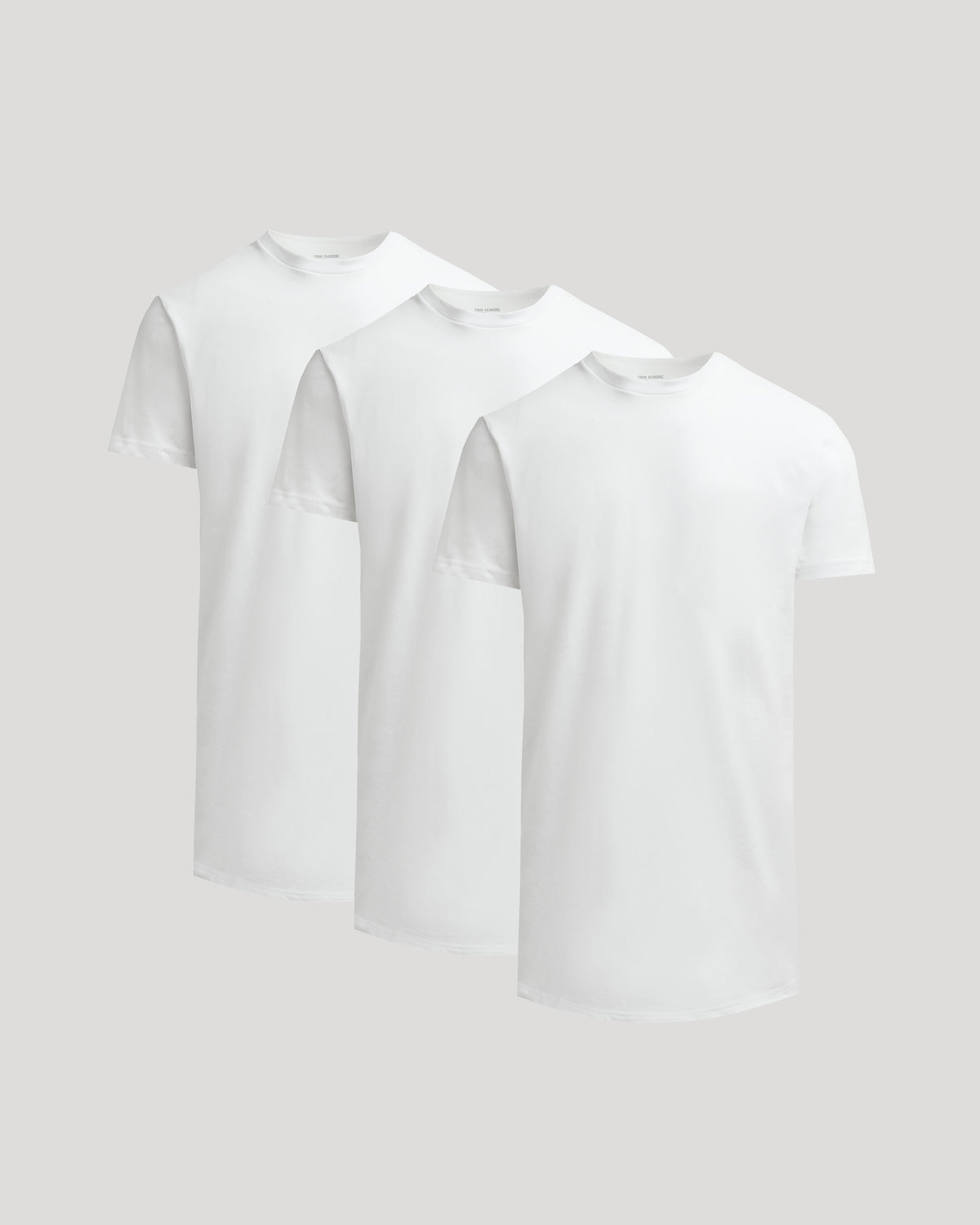 Three white True Classic Men's Tall Heavyweight Curved Hem Crew – Premium Heavyweight Cotton Blend, Extended Length, Athletic Fit, Structured Everyday T-Shirts displayed against a neutral background.