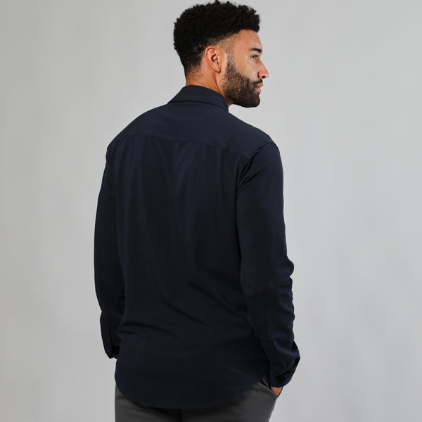 Man modeling Navy Long Sleeve Knit Shirt with dark pants.