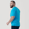 Man in Turquoise Short Sleeve Crew Neck Tee, smiling, mid-step.