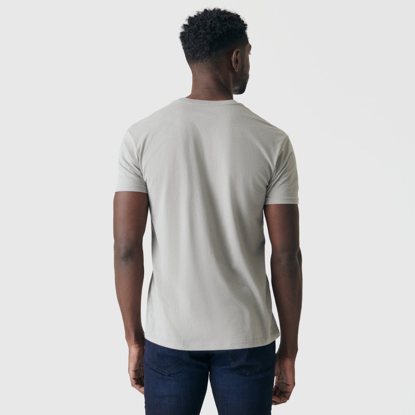 Man wearing Iron Gray Short Sleeve Crew Neck Tee and jeans, back view.
