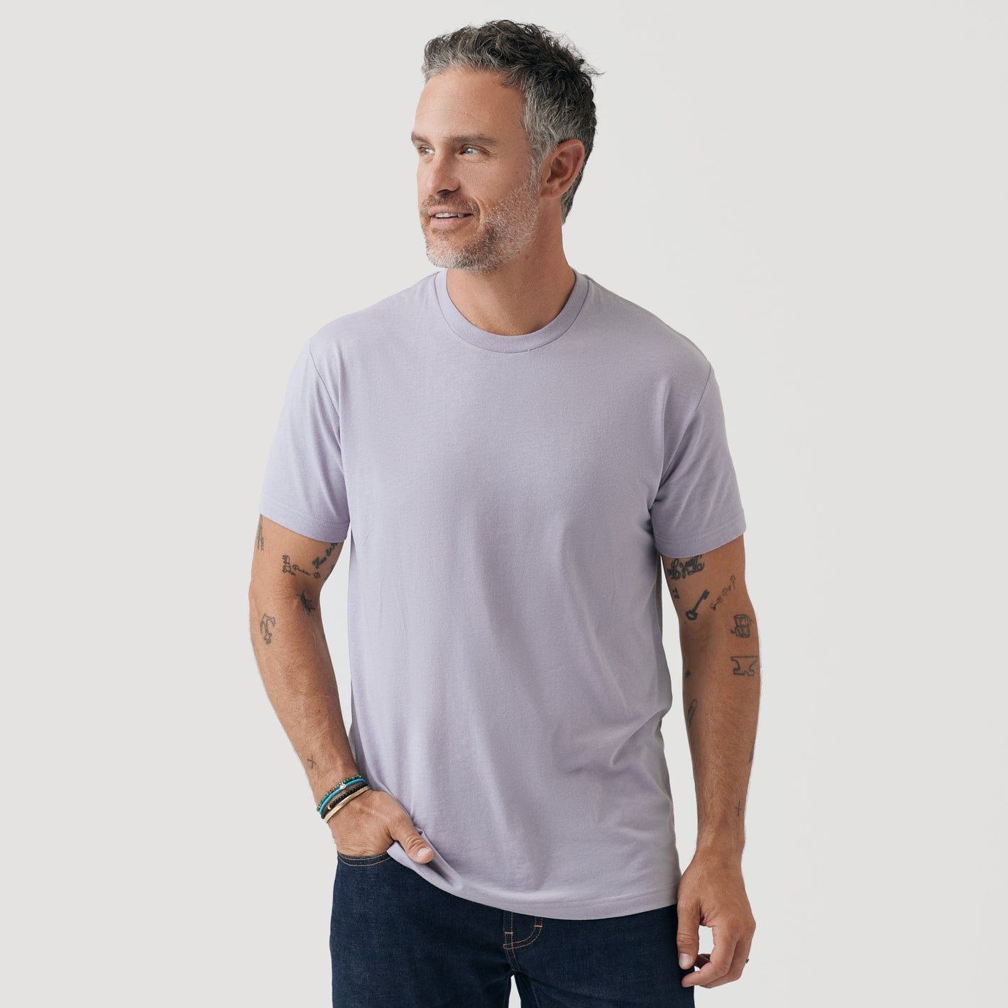 Man wearing Lilac Gray Short Sleeve Crew Neck Tee with dark jeans.