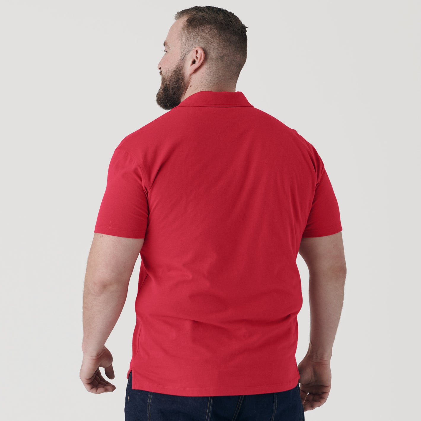 Man wearing Raspberry Classic Polo, back view, short sleeves visible.